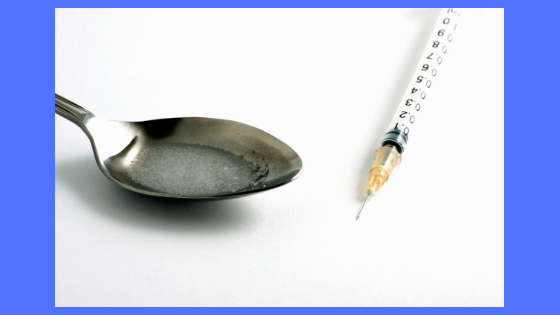 a needle and a spoon with a drug like liquid in it